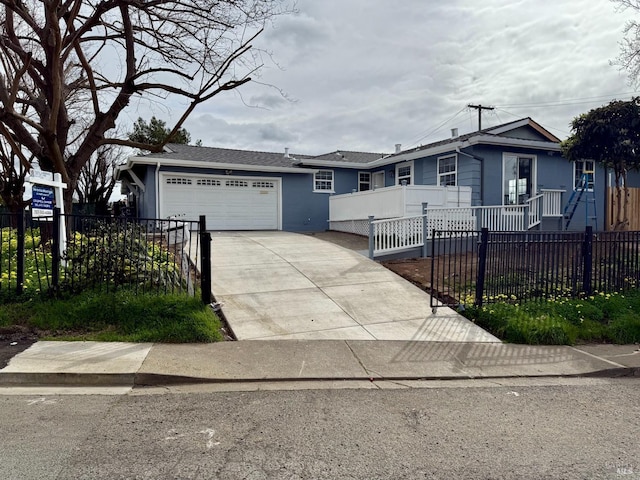 ranch-style house with a garage, driveway, and a fenced front yard