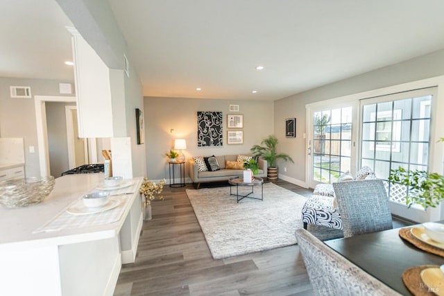 living room featuring baseboards, wood finished floors, visible vents, and recessed lighting