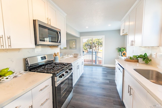 kitchen featuring tasteful backsplash, appliances with stainless steel finishes, white cabinets, and light stone counters