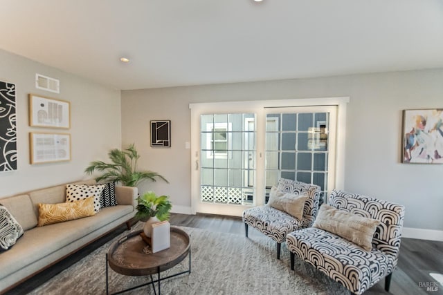 living room with recessed lighting, visible vents, baseboards, and wood finished floors