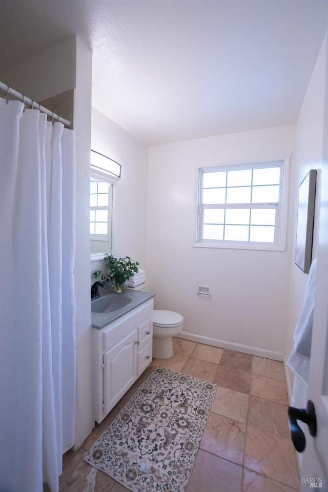 full bathroom featuring toilet, baseboards, and vanity