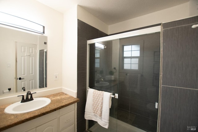 full bathroom featuring a stall shower and vanity