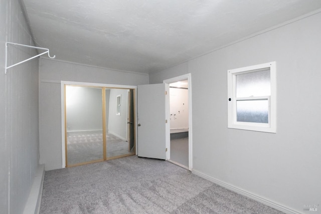 unfurnished bedroom featuring light carpet and a closet