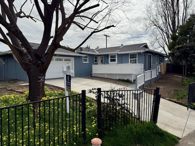 ranch-style home with a fenced front yard, concrete driveway, and an attached garage