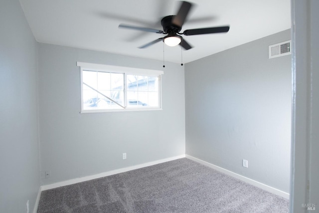 carpeted empty room featuring ceiling fan, visible vents, and baseboards