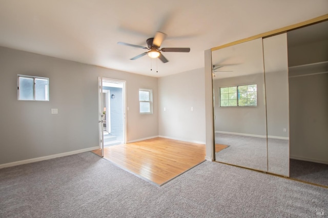 unfurnished bedroom featuring multiple windows, carpet, a closet, and baseboards