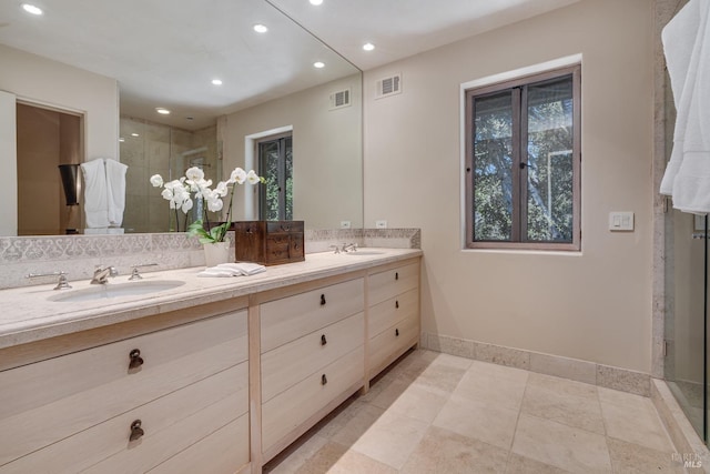 bathroom featuring vanity, a healthy amount of sunlight, and walk in shower