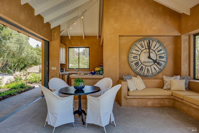 sunroom featuring lofted ceiling with beams