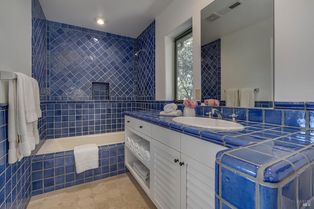 bathroom with tile patterned floors, vanity, tile walls, and shower with separate bathtub