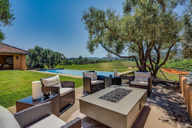 view of patio / terrace with a rural view and an outdoor living space with a fire pit