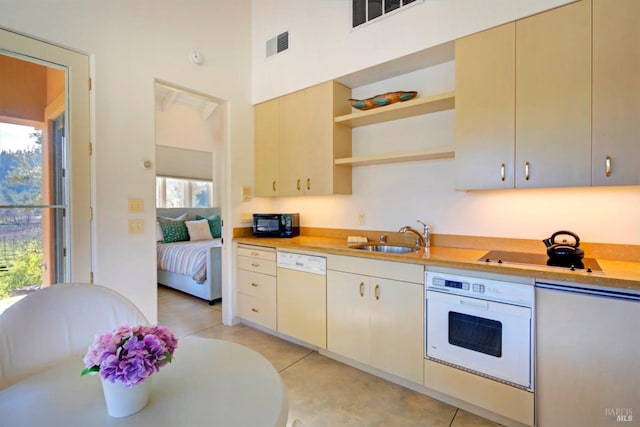 kitchen featuring light tile patterned flooring, white appliances, a wealth of natural light, and sink