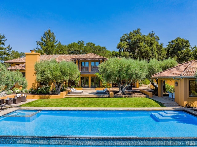 view of pool with outdoor lounge area, an in ground hot tub, a yard, and a patio