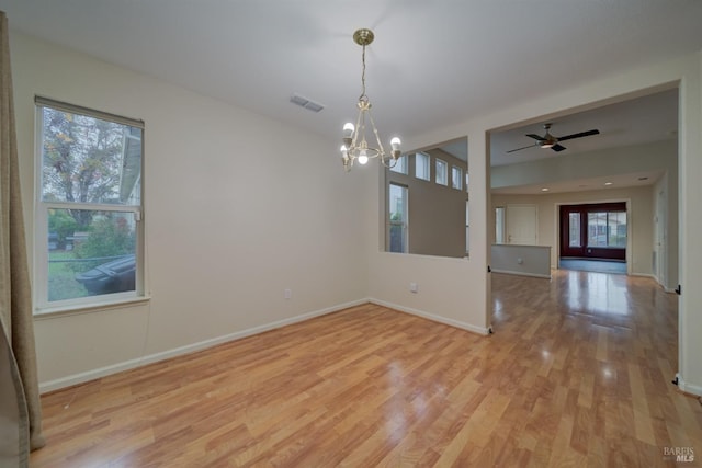 unfurnished room featuring a chandelier and light hardwood / wood-style floors