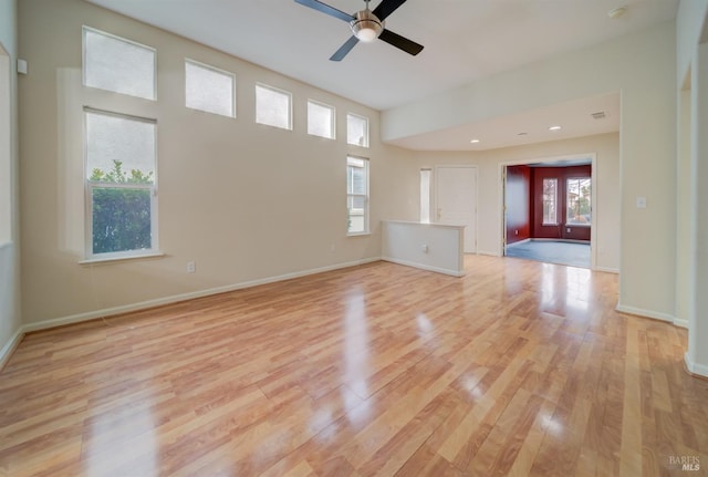 empty room featuring ceiling fan, plenty of natural light, and light hardwood / wood-style flooring