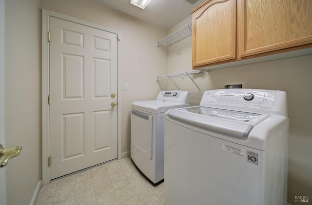 laundry room with cabinets and washing machine and clothes dryer