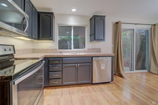 kitchen with light hardwood / wood-style flooring, sink, plenty of natural light, and appliances with stainless steel finishes