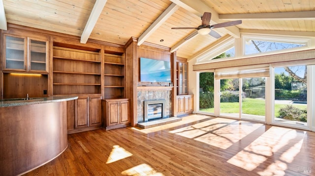 unfurnished living room with wooden ceiling, a fireplace, beamed ceiling, and wood-type flooring