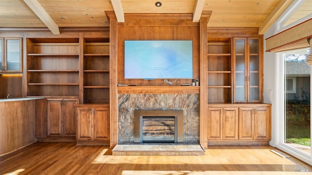 unfurnished living room with light wood-type flooring, plenty of natural light, wooden walls, and wood ceiling