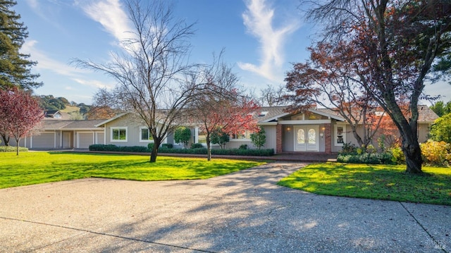 ranch-style house featuring a garage and a front yard