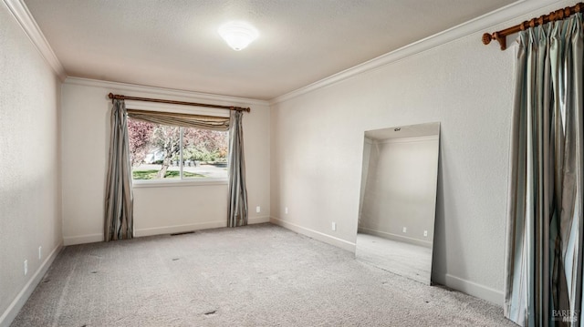 spare room featuring light carpet, a textured ceiling, and crown molding