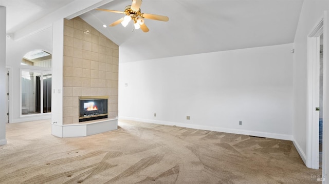 unfurnished living room featuring lofted ceiling with beams, light colored carpet, ceiling fan, and a tiled fireplace