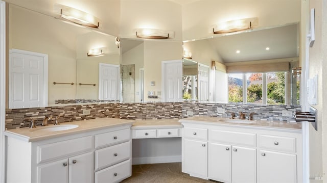 bathroom featuring vanity, tasteful backsplash, and vaulted ceiling