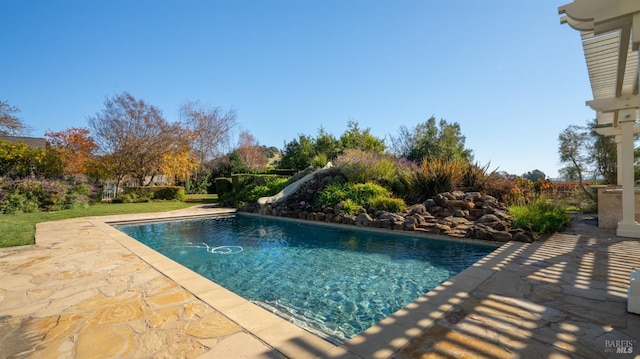 view of swimming pool with a patio and a water slide