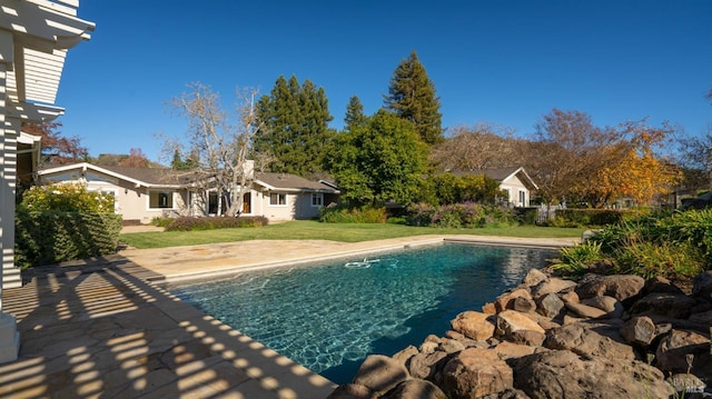 view of swimming pool with a lawn and a patio area