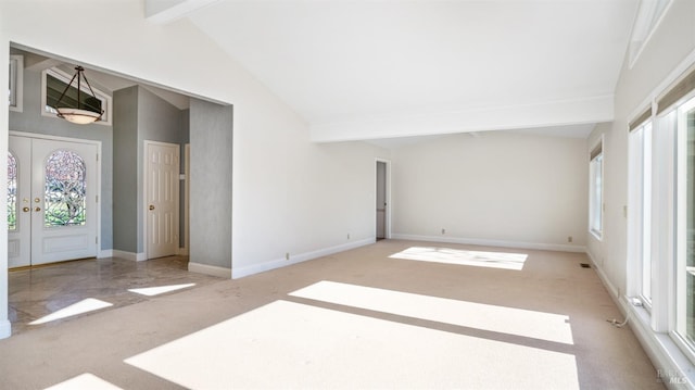 spare room with beamed ceiling, light carpet, and high vaulted ceiling