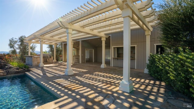 view of patio / terrace featuring a pergola, ceiling fan, and exterior kitchen