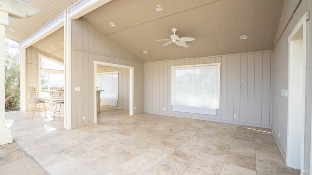 spare room featuring ceiling fan, wood walls, wood ceiling, and high vaulted ceiling