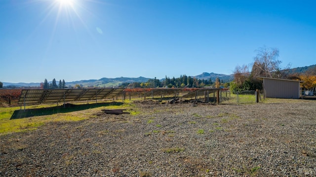 view of yard featuring a mountain view, an outbuilding, and a rural view