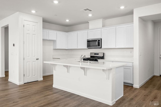 kitchen with a center island with sink, white cabinetry, and stainless steel appliances