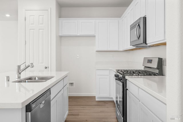 kitchen featuring sink, white cabinets, stainless steel appliances, and light hardwood / wood-style floors