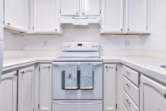 kitchen with range with electric stovetop, tile countertops, and white cabinetry