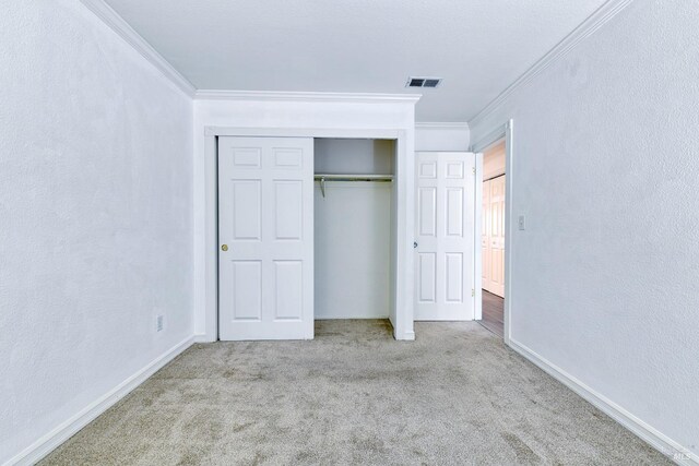 unfurnished bedroom with light carpet, a closet, and ornamental molding