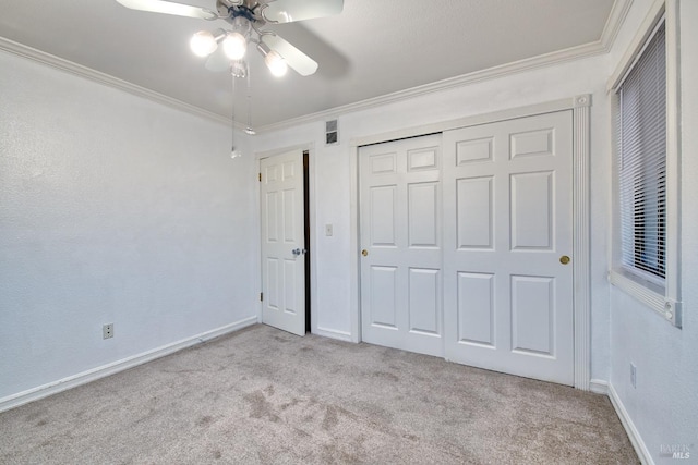 unfurnished bedroom featuring ceiling fan, ornamental molding, and light carpet