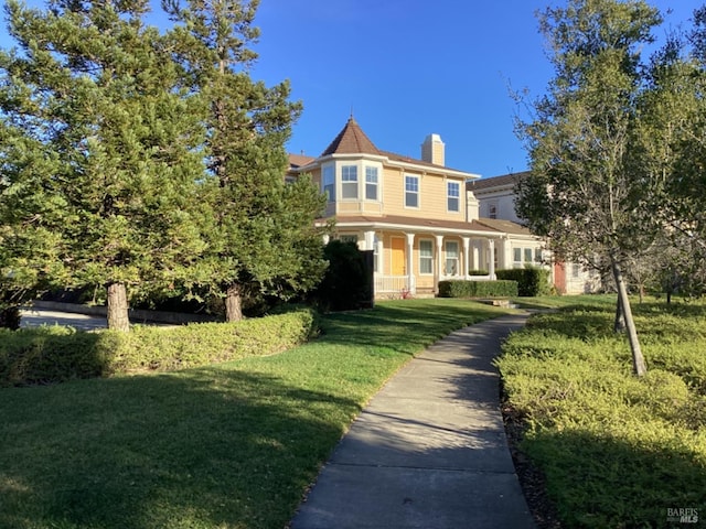 victorian home featuring a front lawn and a porch