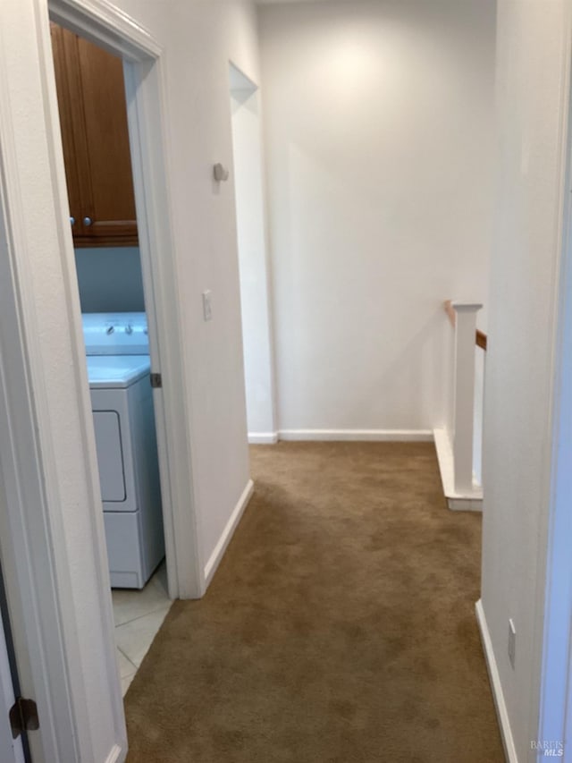 hallway with light colored carpet and washer / dryer