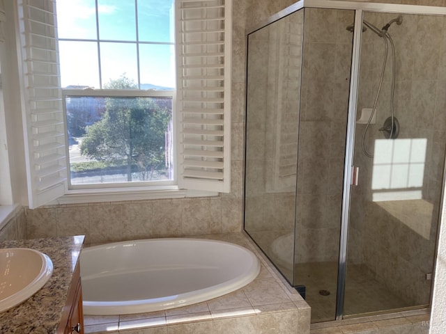 bathroom with vanity and shower with separate bathtub