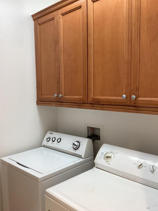 washroom with washer and clothes dryer and cabinets