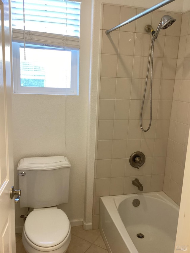 bathroom featuring tiled shower / bath combo, tile patterned floors, and toilet