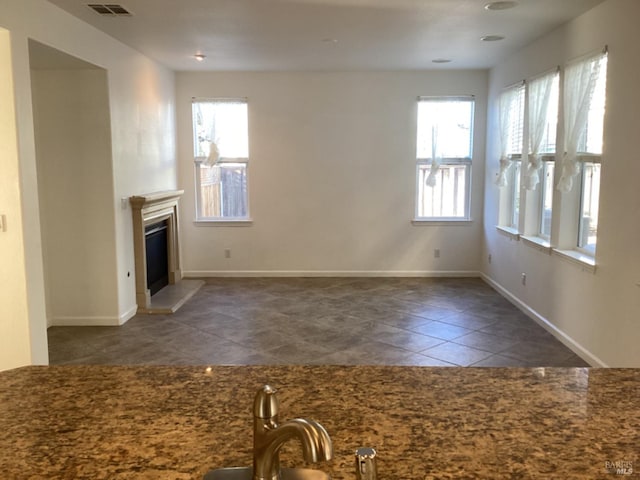 unfurnished living room featuring dark tile patterned floors