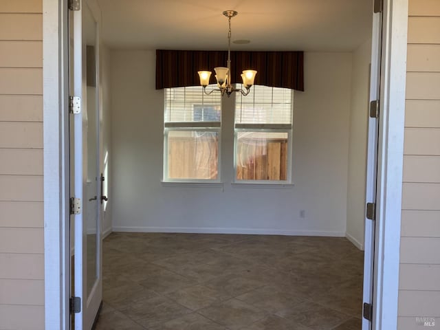 unfurnished dining area with a notable chandelier