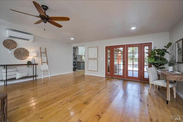 living room featuring ceiling fan, light hardwood / wood-style flooring, a wall unit AC, and french doors