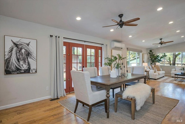 dining room featuring a wall mounted air conditioner, french doors, vaulted ceiling, ceiling fan, and light wood-type flooring