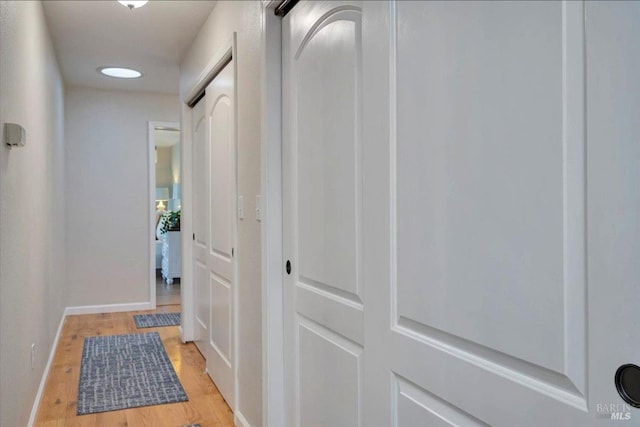 hallway with light hardwood / wood-style floors