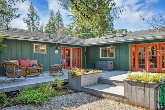 back of house with an outdoor living space, a deck, and french doors