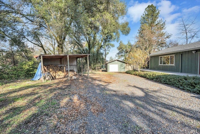 view of yard with a carport, an outdoor structure, and a garage