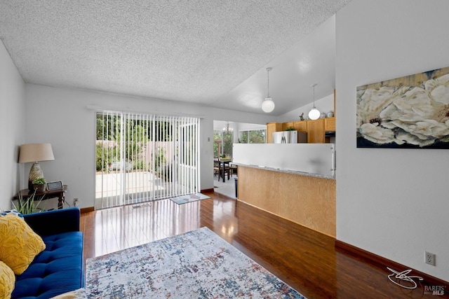 living area featuring baseboards, a textured ceiling, wood finished floors, and vaulted ceiling